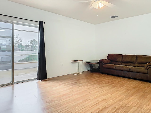 living room with visible vents, a ceiling fan, and light wood-style floors