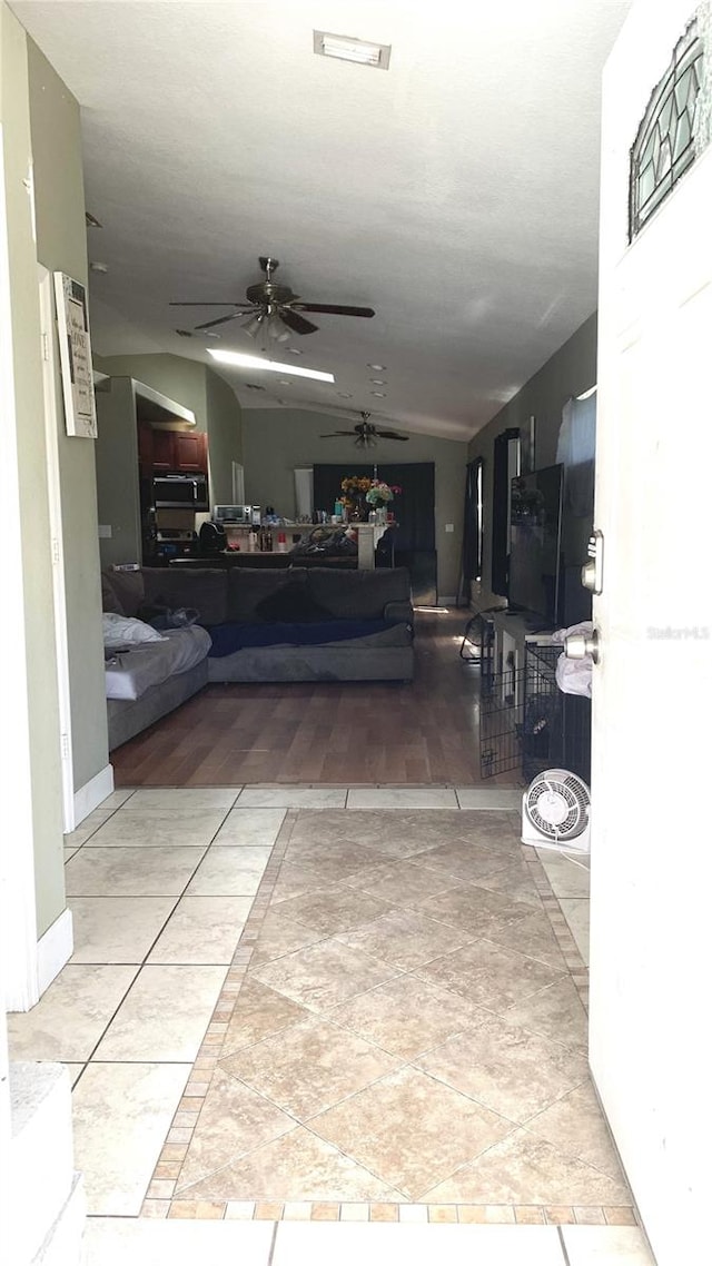 hallway with lofted ceiling and light hardwood / wood-style floors