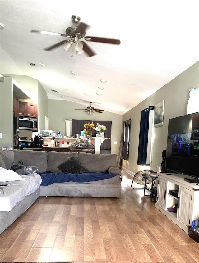 living room with lofted ceiling, light hardwood / wood-style flooring, and ceiling fan