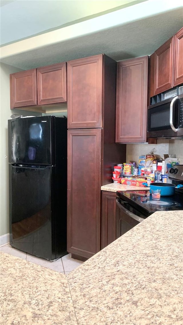 kitchen with light tile patterned flooring and appliances with stainless steel finishes