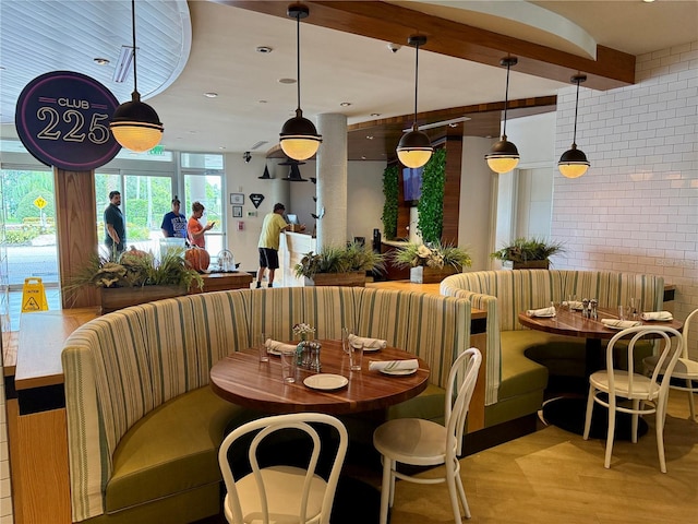 dining space featuring light wood-type flooring and beamed ceiling