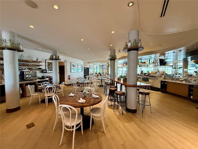 dining space featuring light hardwood / wood-style flooring and indoor bar