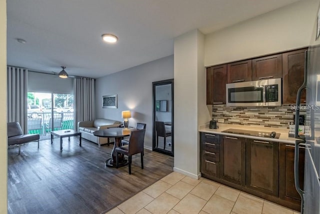 kitchen featuring dark brown cabinetry, ceiling fan, light hardwood / wood-style flooring, black electric cooktop, and decorative backsplash