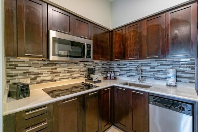 kitchen with dark brown cabinets, stainless steel appliances, sink, and tasteful backsplash