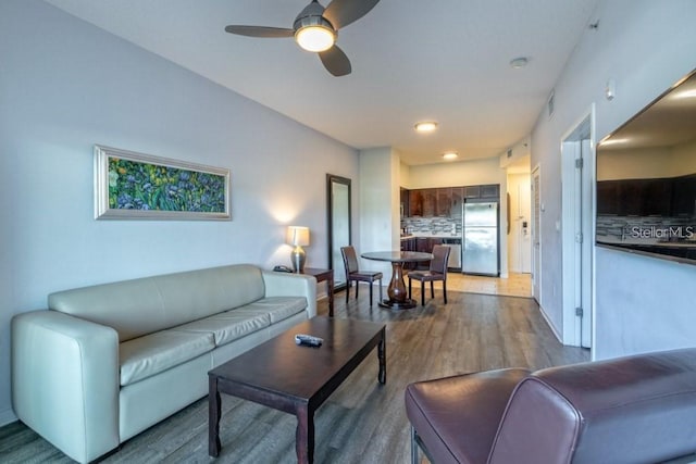 living room featuring hardwood / wood-style floors and ceiling fan