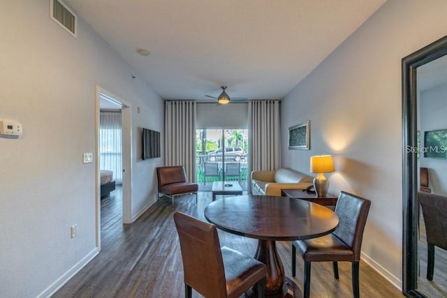 dining area with ceiling fan and dark wood-type flooring