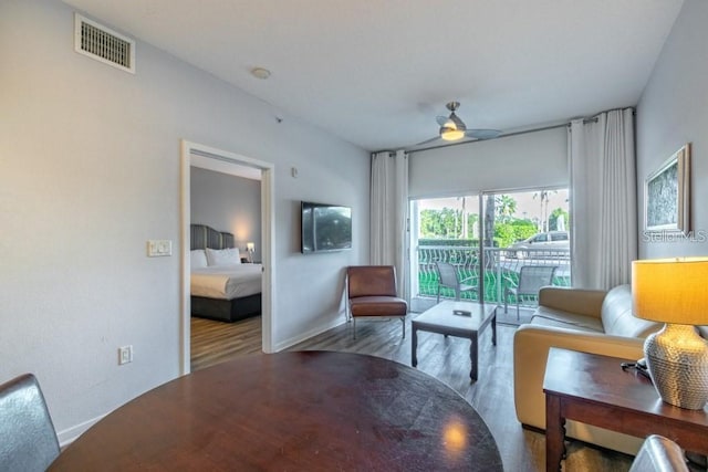 living room featuring wood-type flooring and ceiling fan