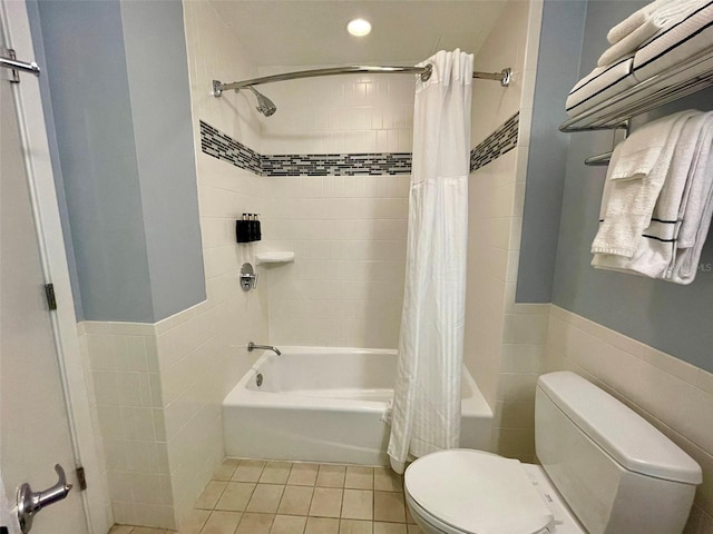 bathroom featuring tile patterned floors, toilet, tile walls, and shower / bath combo