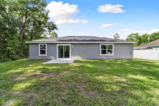 rear view of property featuring a patio and a lawn