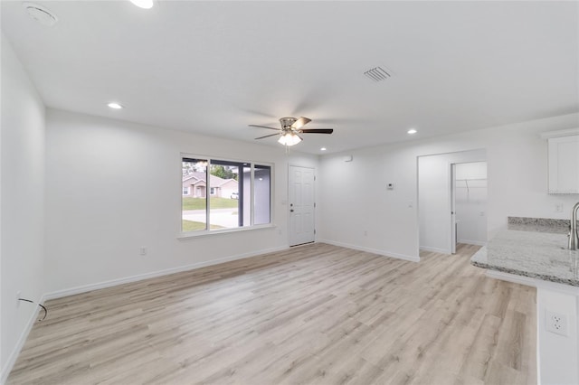 unfurnished living room with ceiling fan and light hardwood / wood-style flooring