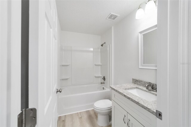 full bathroom featuring vanity, a textured ceiling, shower / tub combination, hardwood / wood-style flooring, and toilet