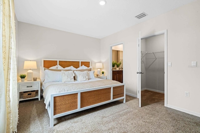 bedroom featuring dark colored carpet, a spacious closet, and a closet