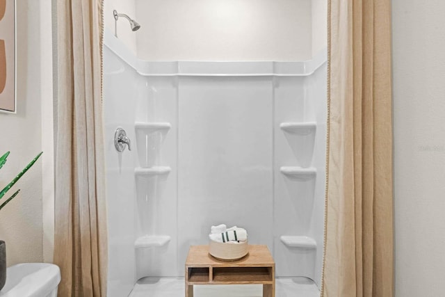 bathroom with toilet and a shower with shower curtain