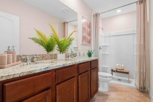 bathroom with tile patterned flooring, walk in shower, vanity, and toilet