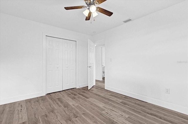 unfurnished bedroom with hardwood / wood-style flooring, ceiling fan, and a closet