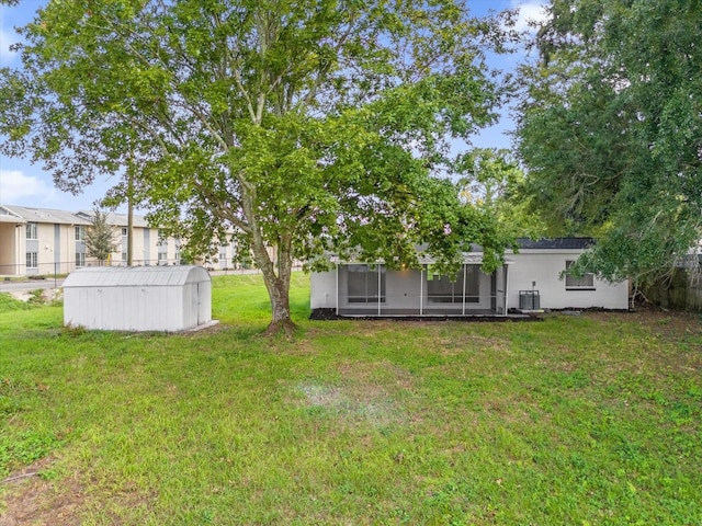 view of yard featuring central AC unit, an outdoor structure, and a sunroom