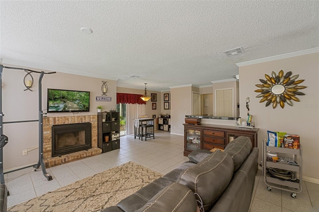 living room with a textured ceiling, light tile patterned floors, a brick fireplace, and crown molding