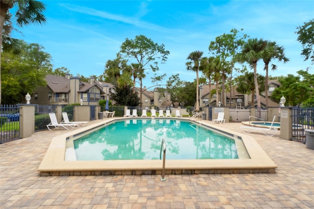 view of swimming pool featuring a community hot tub and a patio