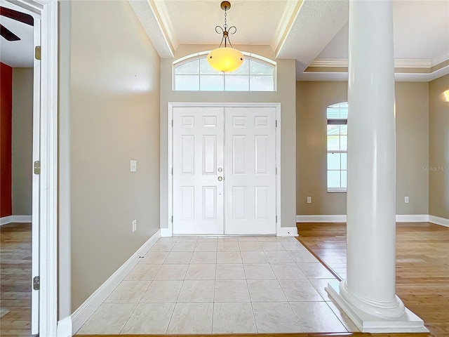 foyer entrance featuring a textured ceiling, ornate columns, light hardwood / wood-style floors, ceiling fan, and crown molding