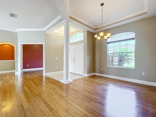 entrance foyer featuring ornamental molding, a chandelier, light wood-type flooring, and decorative columns