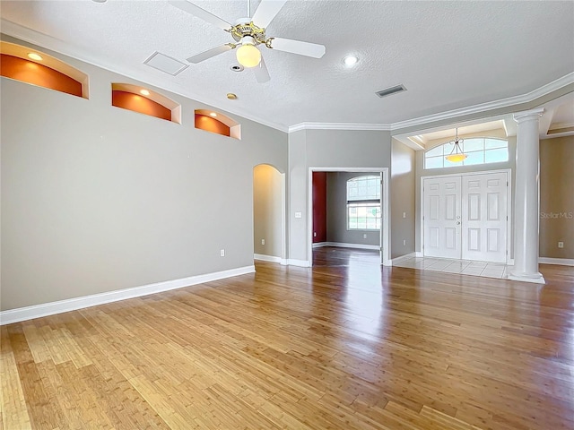 unfurnished living room featuring lofted ceiling, ornamental molding, light wood-type flooring, a textured ceiling, and ceiling fan