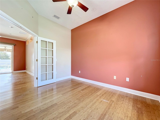 unfurnished room with vaulted ceiling, light hardwood / wood-style flooring, a textured ceiling, and ceiling fan