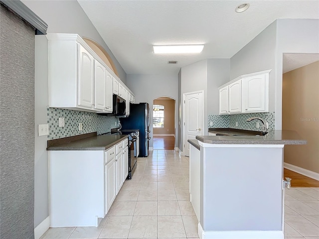 kitchen featuring appliances with stainless steel finishes, white cabinetry, kitchen peninsula, and light tile patterned floors