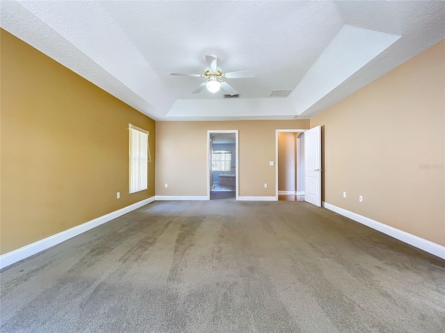 unfurnished room with carpet flooring, ceiling fan, a textured ceiling, and a raised ceiling