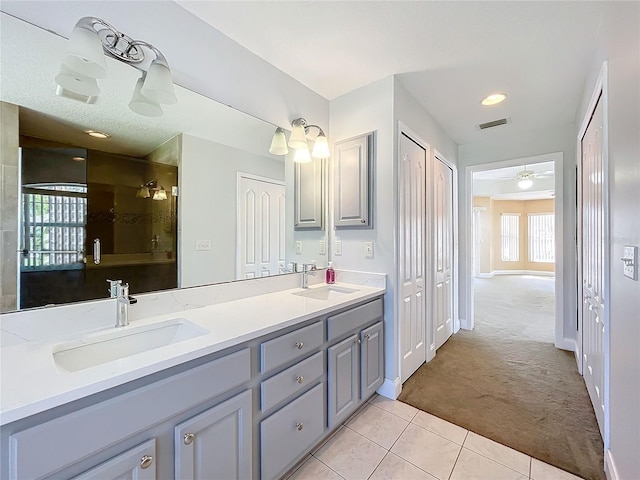 bathroom featuring walk in shower, vanity, ceiling fan, and tile patterned flooring