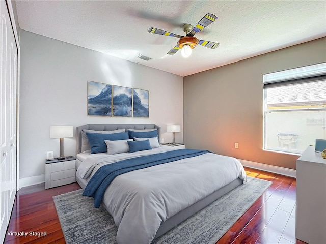 bedroom featuring a textured ceiling, hardwood / wood-style flooring, a closet, and ceiling fan