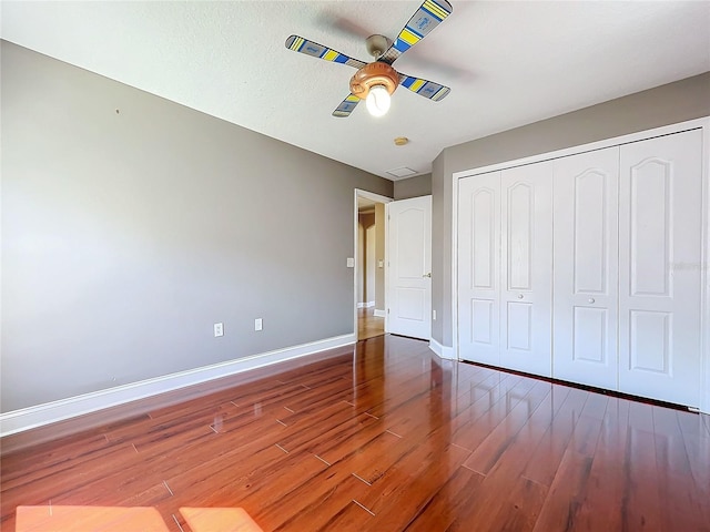 unfurnished bedroom featuring a closet, ceiling fan, a textured ceiling, and hardwood / wood-style floors