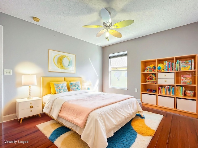 bedroom featuring dark wood-type flooring, a textured ceiling, and ceiling fan