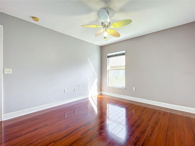 unfurnished room featuring a textured ceiling, dark wood-type flooring, and ceiling fan