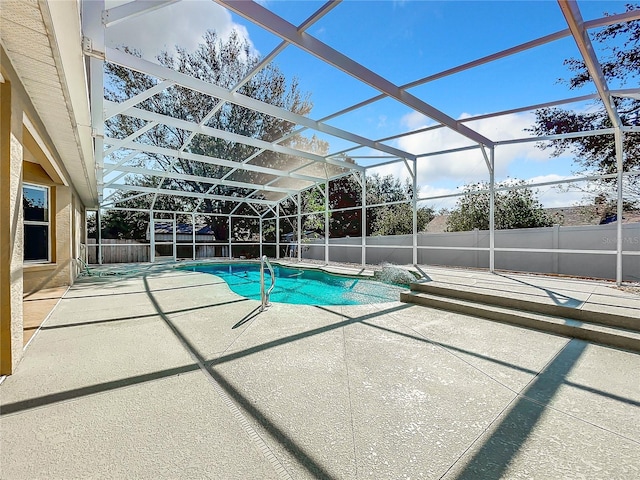 view of swimming pool with a patio area and a lanai