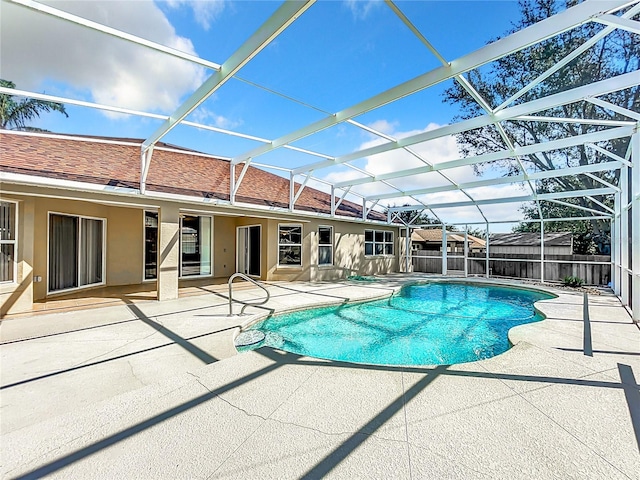 view of swimming pool with a patio area and glass enclosure