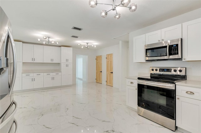 kitchen with a chandelier, appliances with stainless steel finishes, and white cabinetry