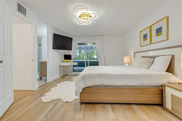 bedroom featuring a textured ceiling and hardwood / wood-style flooring