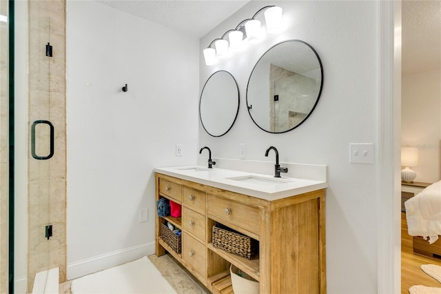 bathroom featuring vanity, hardwood / wood-style floors, a shower with shower door, and a textured ceiling