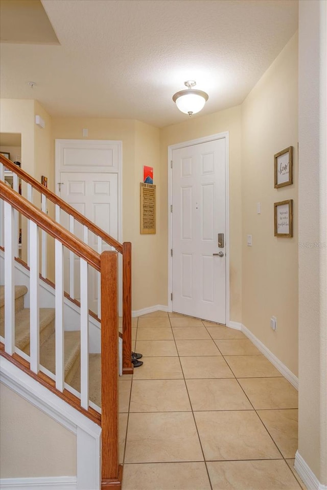 entrance foyer with a textured ceiling and light tile patterned floors