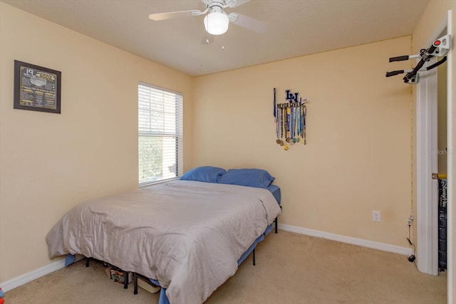 bedroom with ceiling fan and light carpet