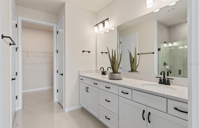 bathroom featuring tile patterned floors, a shower with door, and vanity