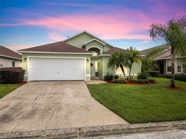 ranch-style house with a garage and a lawn