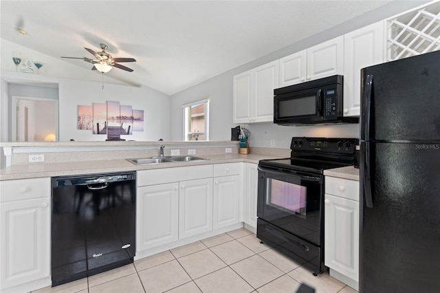 kitchen featuring lofted ceiling, black appliances, white cabinetry, and light tile patterned floors