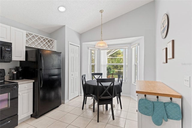 kitchen featuring pendant lighting, lofted ceiling, white cabinetry, and black appliances