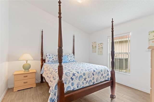 bedroom with light wood-type flooring and a textured ceiling