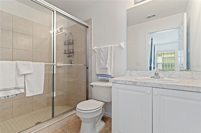 bathroom with a shower with door, tile patterned floors, vanity, and toilet