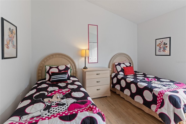 bedroom with vaulted ceiling and light hardwood / wood-style floors