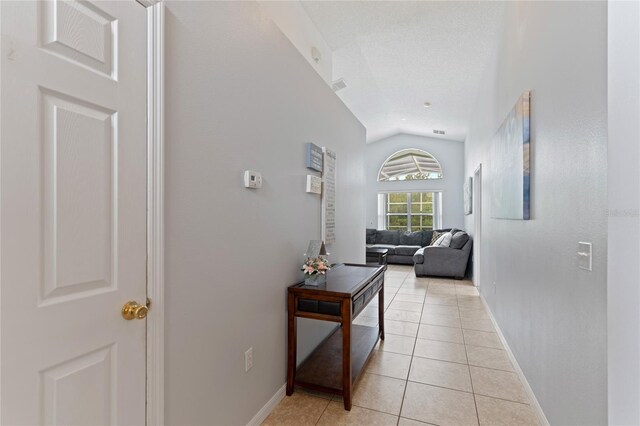 246 Kimberly Point Dr, Davenport, FL 33837 - corridor with lofted ceiling, light tile patterned flooring, and baseboards