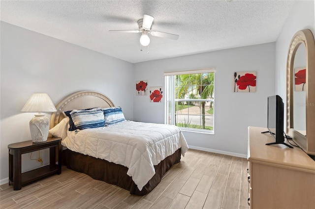 246 Kimberly Point Dr, Davenport, FL 33837 - bedroom featuring light wood finished floors, baseboards, a textured ceiling, and a ceiling fan