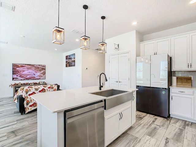 kitchen featuring white cabinetry, sink, appliances with stainless steel finishes, and an island with sink